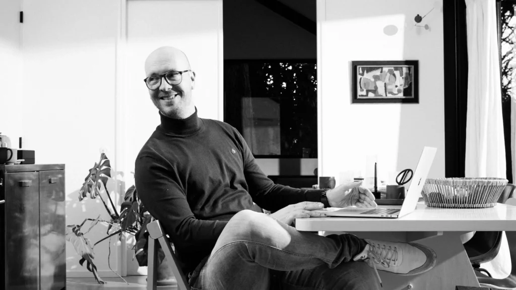 Erwin Bakker van Bakker Ontwerp zittend op een stoel in een studio